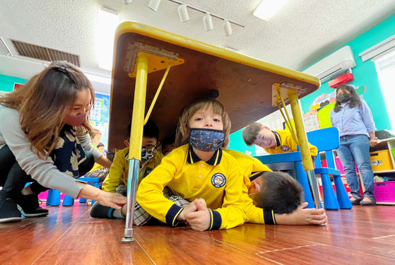 가주의 연례 '지진대비 훈련의 날(Great California shakeout)'을 맞아 각급 학교는 이번 한 주 동안 일정을 자율적으로 정해 훈련을 진행한다. 20일 베벌리어린이학교(원장 줄리 조) 원생들이 지진 발생경보가 울리자 교사의 지도에 따라 책상 밑으로 대피하고 있다. 김상진 기자