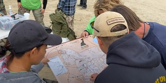 마야 밀레테의 시신을 찾기 위해 모인 가족과 지인 그리고 자원봉사자들이 안자 보레고 주립 사막공원의 지도를 보면서 수색 구역을 나누고 있다.