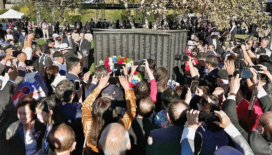 지난 11일 풀러턴의 힐크레스트 공원에서 열린 참전용사비 제막식 참석자들이 오각별 모양의 기념비 주위에 몰려들어 사진을 찍고 있다. 김상진 기자