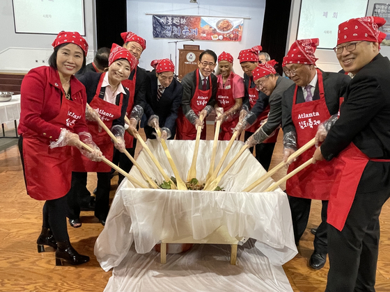 지난 13일 오전 노크로스 애틀랜타한인회관에서 2021 김치 축제 참가자들이 비빔밥을 비비는 퍼포먼스를 하며 사진을 찍었다.