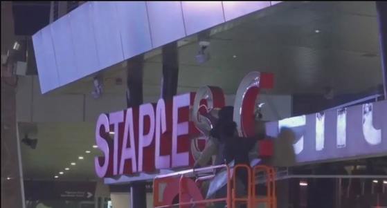 LA레이커스의 홈구장 스테이플스 센터가 명칭이 25일부터 ‘크립토닷컴 어리나’로 변경된다. 지난 20여 년 동안 자리를 지켜온 스테이플스 센터 상단에 있는 적색의 ‘Staples Center’ 로고가 6일 철거 작업에 들어갔다.  [온신 TV 캡처] 