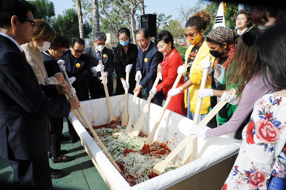 제1회 오렌지카운티 김치 축제 개막식 참가자들이 김치 양념을 버무리고 있다. 오른쪽 빨간 색 옷을 입은 이가 캐롤 이 코리안소울푸드재단 이사장. [재단 제공]