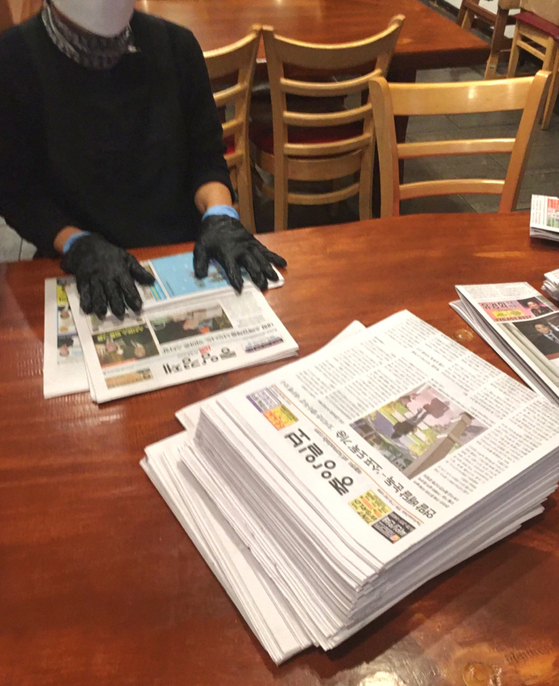 둘루스의 한 식당에서 종업원이 당일자 중앙일보 신문을 쌓아놓고 배당용 받침대로 접고 있다. [독자 제공]