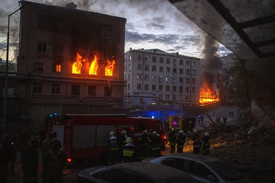 러시아군이 쏜 미사일이 28일 키이우 건물을 강타해 화재가 났다. 볼로디미르 젤렌스키 우크라이나 대통령은 이날 키이우에서 유엔 사무총장을 만났다. AP=연합뉴스