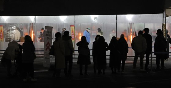 25일 저녁 서울 송파구 잠실종합운동장 제2주차장 임시선별검사소를 찾은 시민들이 검사를 기다리고 있다. [연합뉴스]