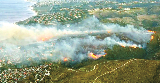 라구나비치 지역 주택가 인근 산등성이에서 발생한 산불이 번지고 있다. [ABC7 캡처]