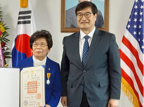 필라이북5도민연합회 이헬렌(한국이름 임명분·왼쪽) 회장이 지난 12일 ‘대한민국 국민포장’을 받았다. 이날 수여식에는 정병화 뉴욕총영사가 필라출장소를 방문해 이 회장의 공로를 치하하고 포장을 수여했다. [필라이북5도민연합회]