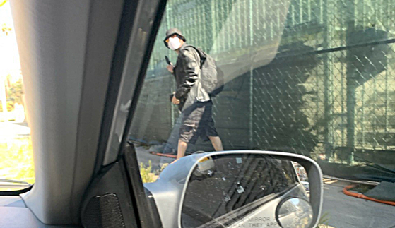 김모씨가 차 안에서 달아나는 괴한의 사진을 찍었다. 이 남성이 김씨 부부를 향해 품속에 있는 칼을 슬쩍 꺼내 위협하고 있는 모습.
