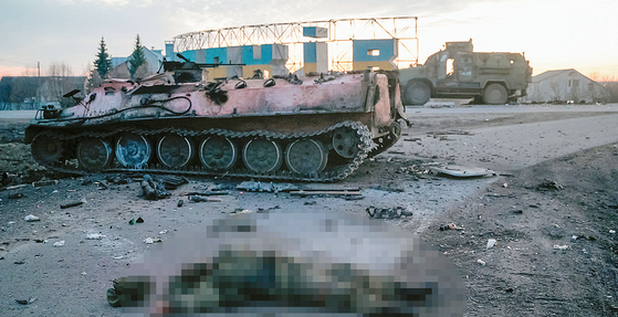 러시아가 우크라이나를 전면 침공한 24일(현지시각) 우크라이나 북동부 하리코프의 외곽 거리에 부서진 장갑차와 휘장 없는 군복 차림의 병사가 숨진 채 쓰러져 있다. 사망한 군인의 국적은 확인되지 않았다. [로이터]