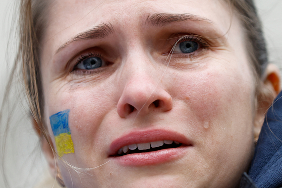  25일 영국 런던에서 열린 러시아의 우크라이나 침공 규탄시위에서 우크라이나 출신 이민자가 눈물을 흘리고 있다. 이 여성의 가족은 우크라이나의 수도 키예프에 거주하고 있는 것으로 알려졌다. [로이터]