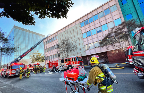 10일 오후 LA한인타운 한 건물에서 발생한 화재현장에서 구급대원들이 들것을 옮기고 있다. 김상진 기자