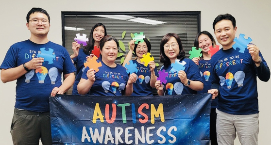 한미특수교육센터 로사 장(오른쪽에서 세 번째) 소장이 직원들과 함께 '자폐증 인식의 달' 배너를 들어 보이고 있다. ［센터 제공］