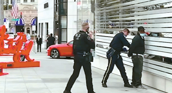 지난달 31일 오후 경찰관들이 로데오 거리 명품 매장 앞에서 절도 용의자를 체포하고 수갑을 채우고 있다. [ABC7 캡처]