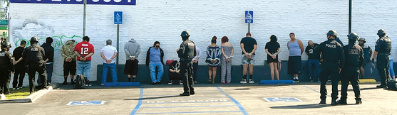 LA경찰국 소속 중무장 경관들이 15일 오후 LA한인타운에서 불법으로 운영되던 한 도박장을 급습 현장에서 20여명을 체포했다. 경관들이 현장에서 체포한 불법 도박 관련자들을 수갑을 채운 채 인근 주차장 벽에 세워두고 조사를 하고 있다. 김상진 기자