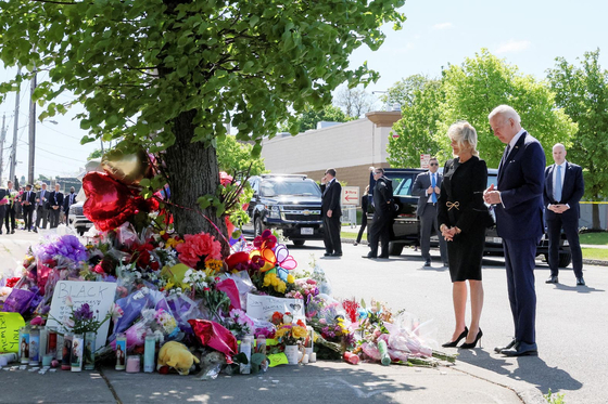 17일 버팔로 총격사건 현장을 방문한 조 바이든 대통령(오른쪽)이 부인 질 바이든 여사와 함께 희생자를 추모하고 있다.  [로이터]