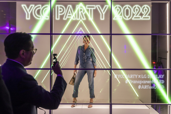 1일 구겐하임 뮤지엄에서 열린 YCC파티에서 참석자들이 LG디스플레이 55인치 투명 OLED 9대로 홀로그램을 구현한 대형 포토월에서 기념촬영을 하고 있다. [사진 LG] 