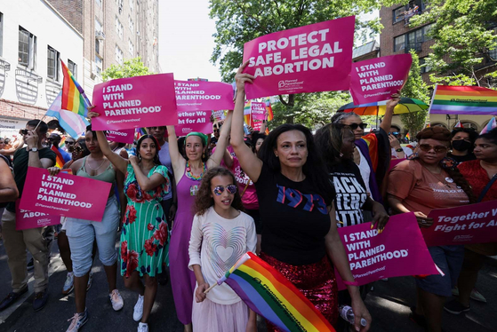 26일 맨해튼에서 진행된 ‘2022 뉴욕시 프라이드 퍼레이드’ 참가자들이 낙태권을 옹호하는 문구를 담은 포스터를 들고 행진하고 있다. [사진 로이터] 