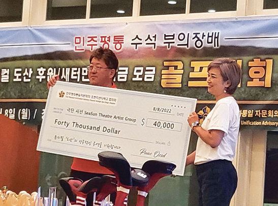 김동수(왼쪽) 회장이 클라라 신 대표에게 후원금을 전달하고 있다. [평통 제공]