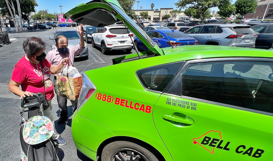 10일 오후 LA 한인타운 인근 본스 마켓 주차장에서 벨 택시 운전기사가 시니어의 장바구니를 트렁크에 싣고 있다. 김상진 기자