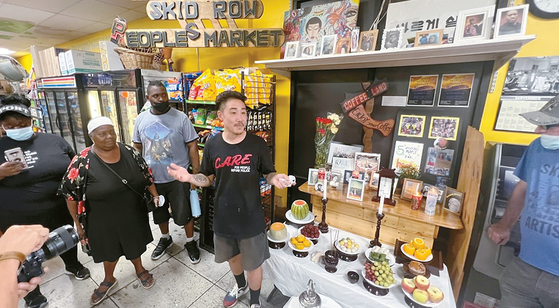 스키드로에 위치한 ‘피플스마켓’의 대니 박(가운데) 사장이 9일 지역 주민들과 노숙자들에게 한국 명절 추석과 차례의 의미를 설명하고 있다. 김상진 기자