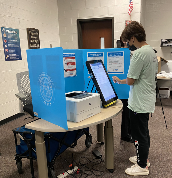 한글로 된 투표용지를 체험해보고 있는 학생. 