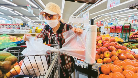 2025년부터 가주 식료품점에서 일회용 비닐 봉투 사용 금지 법안이 시행 예정인 가운데 한인마켓에서 쇼핑객이 일회용 비닐 봉투를 사용해 식품을 담고 있다.  김상진 기자 