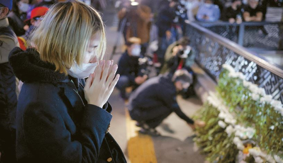 30일(한국시각) 서울 이태원 압사 참사 현장 인근에 시민들의 추모 발걸음이 이어지고 있다. 한 시민이 기도를 하고 있다. [로이터]