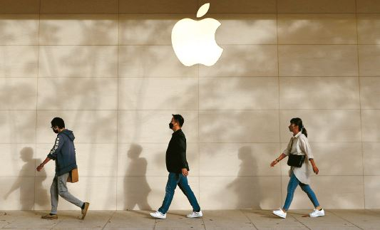 애플이 축구 중계를 통해서 광고 수익 증대를 모색 중이다. 사람들이 애플 로고 앞을 지나고 있다. [로이터]