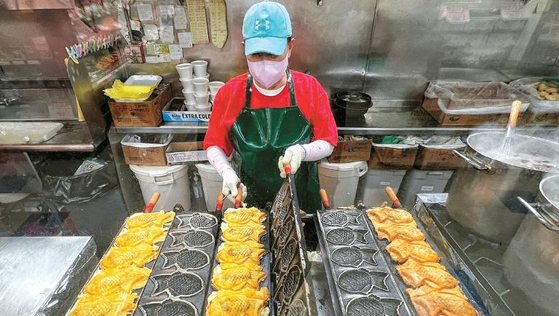 30년째 붕어빵을 판매하고 있는 한국마켓 내 한국치킨에서 직원이 팥앙금 붕어빵을 굽고 있다. 김상진 기자