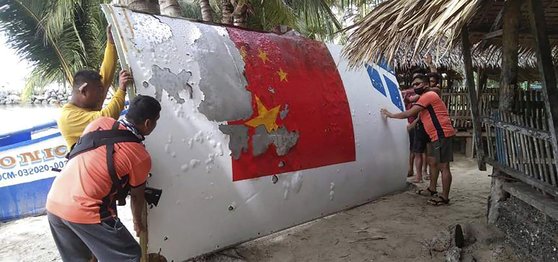 지난해 8월 필리핀 해안경비대가 남중국해 인근에서 중국이 지난해 7월에 발사한 창정5B 로켓의 잔해를 발견해 살펴보고 있다. AP=연합뉴스