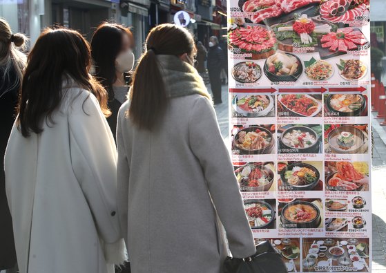 서울 중구 명동 거리에서 시민들이 식당 메뉴를 보고 있다. 뉴스1