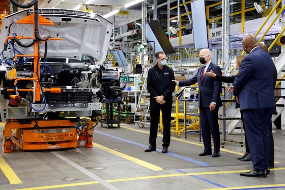 지난해 11월 미국 미시간주 디트로이트에서 조 바이든 미국 대통령(가운데)과 매리 바라 GM CEO가 전기차 생산 공장 앞에서 대화를 나누고 있다. 로이터=연합뉴스