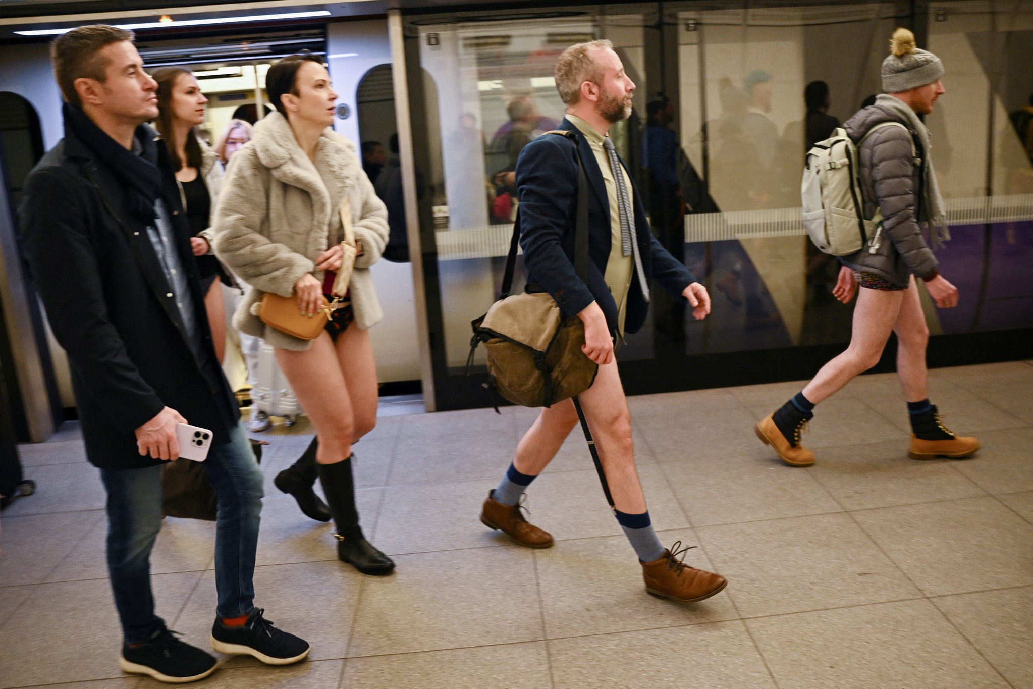 8일(현지시간) 영국 런던에서 열린 ‘바지 벗고 지하철 타기(No Trousers Tube Ride)’에 참가한 시민들이 지하철에서 내려 이동하고 있다. 이 행사는 코로나19로 중단됐다가 3년 만에 다시 열렸다. 로이터=연합뉴스