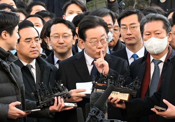 10일 수원지검 성남지청에 출석한 이재명 더불어민주당 대표가 입장문 낭독 전 검지손가락을 입에 대며 “쫄았습니까”라고 한 시민에게 조용히 해달라는 손짓을 하고 있다. [사진공동취재단]