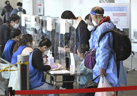 지난 8일 중국 상하이에서 출발해 일본 나리타 공항에 도착한 여행객들이 코로나19 음성증명서 확인 등 입국 절차를 밟고 있다. AP=연합뉴스