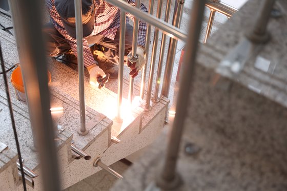 지난달 24일 오후 대구 수성구 한 호텔 계단에서 작업자가 난간 살대를 추가 설치하기 위해 용접을 하고 있다. 연합뉴스