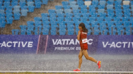 폭우 뚫고 달리는 캄보디아의 보우 삼낭 선수. 사진 IOC 제공