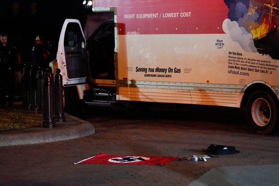 23일(현지시간) 미국 워싱턴 백악관 건너편 라파예트 공원에서 미 비밀경호국 등이 울타리에 충돌한 트럭을 조사하고 있다. 바닥에는 트럭 운전자가 소지한 것으로 보이는 나치 깃발이 깔려 있다. 로이터=연합 