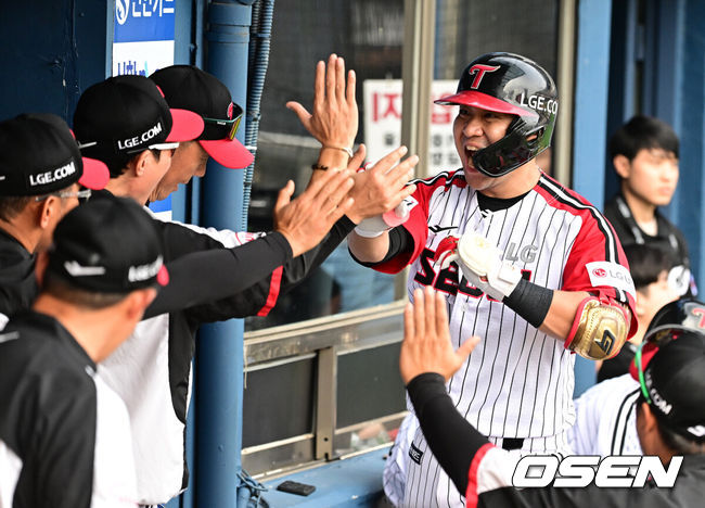 LG 김민성이 오지환에 이어 백투백 홈런을 날리며 더그아웃에서 코칭스태프와 기뻐하고 있다. / OSEN DB
