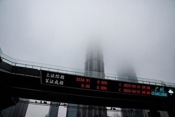중국의 경제 수도 상하이 푸둥의 루자쭈이 금융가의 주가지수 전광판 뒤의 마천루에 짙은 구름이 드리워져 있다. 로이터=연합뉴스
