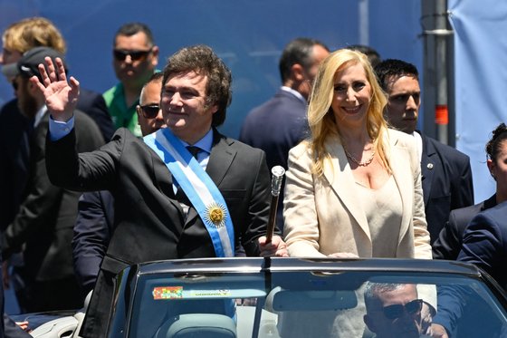 아르헨티나의 새 대통령 하비에르 밀레이(왼쪽)과 그의 여동생 카리나 밀레이가 10일(현지시간) 수도 부에노스아이레스에서 열린 취임식 퍼레이드에서 오픈카를 타고 행진하고 있다. AFP=연합뉴스
