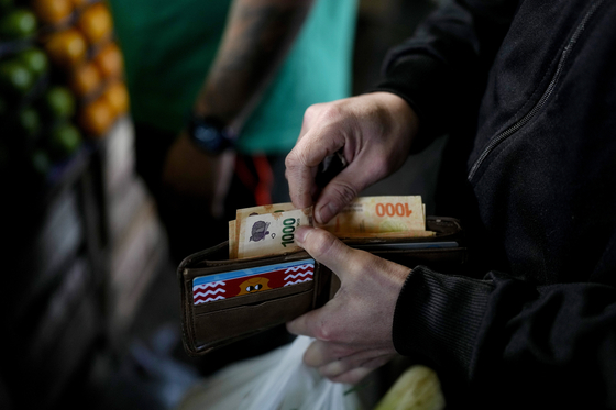 아르헨티나 한 국민이 지갑에서 1000페소 지폐를 꺼내고 있다. AP=연합뉴스