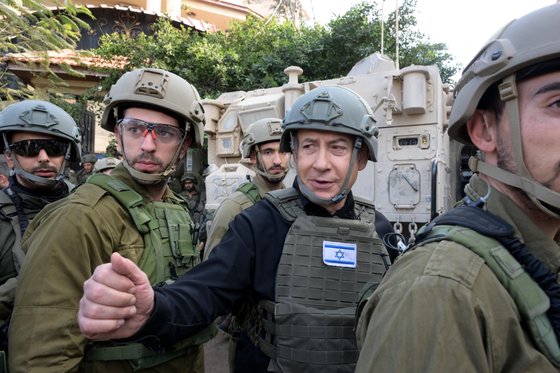 베냐민 네타냐후 이스라엘 총리(가운데)가 25일 가자지구 북부에 있는 이스라엘군부대를 방문해 대화하고 있다. 신화=연합뉴스