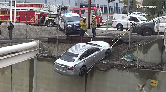 남가주를 강타한 폭우로 각종 피해가 속출한 가운데 4일 오후 LA의 한 도로에서 승용차가 빗길에 미끄러지면서 아슬아슬하게 난간에 걸리는 사고가 발생했다. 승용차에 탑승한 두 명의 여성은 큰 부상 없이 안전하게 구조됐다. [픽스뉴스 캡처]