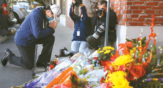 몬터레이 파크 총격 사건이 일어난 스타 볼룸 댄스 스튜디오 밖에서 23일 한 남성이 희생자들을 추모하고 있다. [로이터]
