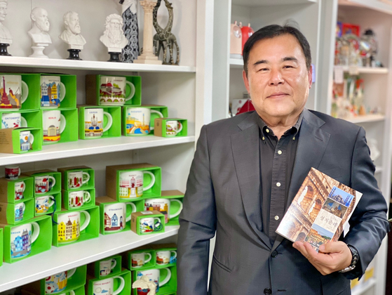드림투어 부에나파크 본사에서 김성근 대표가 자신이 수집한 여행 기념품을 배경으로 저서 '미리 보는 성지순례' 가이드북을 소개하고 있다. 박낙희 기자