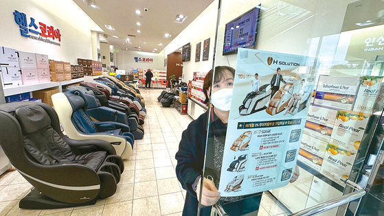 헬스코리아에서 직원이 무이자 할부 프로그램이 적용되는 제품 홍보 전단지를 붙이고 있다. 김상진 기자