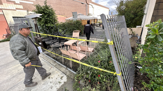 22일 오후 LA한인타운 한복판에서 벌어진 차량 추격전 끝에 부서진 한 건물 주차장의 철문을 관리인이 살펴보고 있다. 김상진 기자