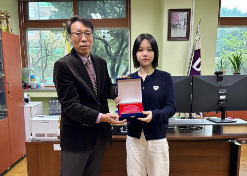 Daniel School awards a plaque of appreciation to Minju Kang.