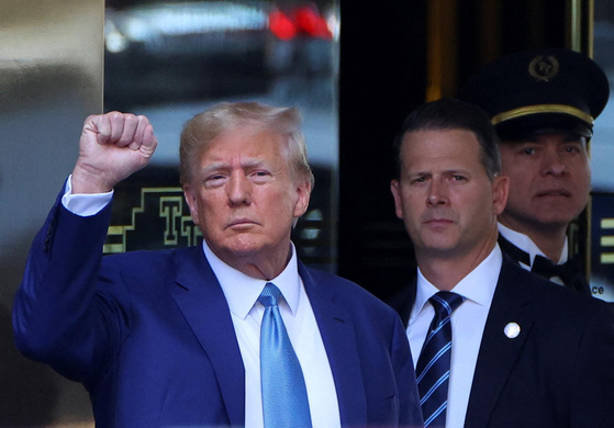 13일 뉴욕에 도착한 도널드 트럼프 전 대통령이 트럼프타워 앞에서 지지자들을 향해 주먹을 쥐고 있다. [로이터]
